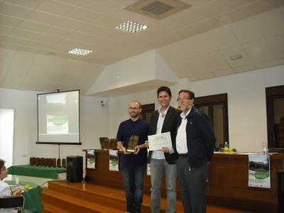 Miguel Antúnez (izquierda) y Antonio Gomera (centro), del Aula de Sostenibilidad, recogen el reconocimiento de manos de Luis Rallo (derecha), miembro del Comité Organizador.
