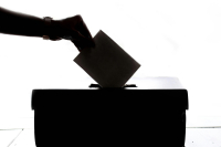 Mano introduciendo un sobre con su votación en una urna