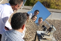 Manuel Torres, Marta Varo y Rafael López Luque, reflejados en el helióstato que han creado para iluminar zonas de umbría.