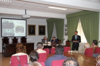 Rafael Jordano ( de pie) durante la presentación del libro. Al fondo las dos fotos que lo inspiran.